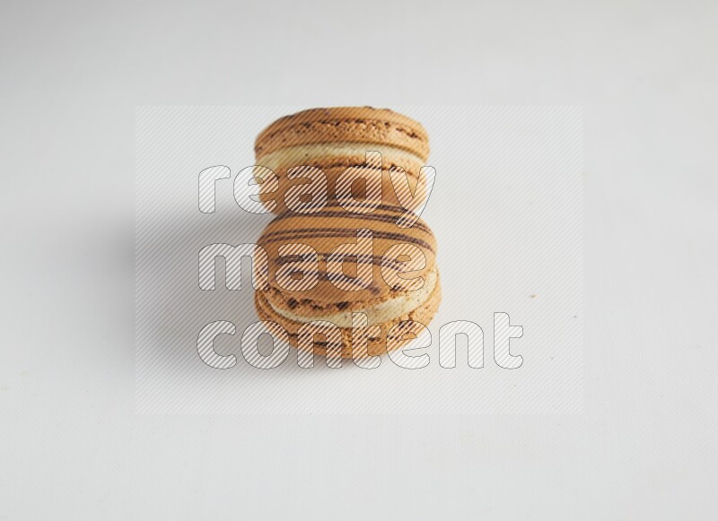 45º Shot of two light brown  Almond Cream macarons on white background