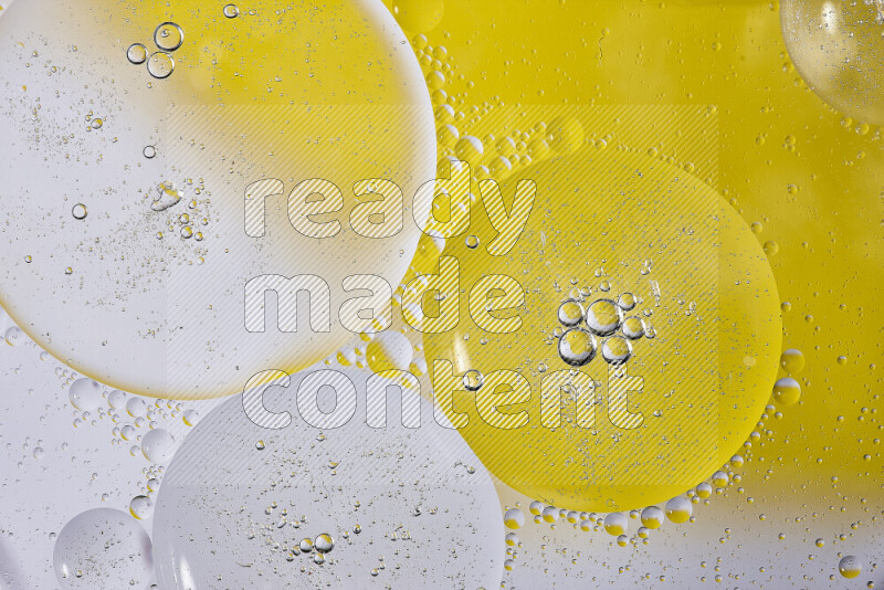 لقطات مقربة لفقاعات من الزيت على سطح الماء باللون الأبيض والأصفر
