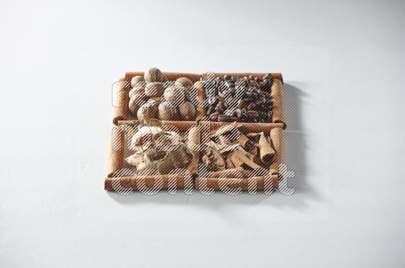 4 squares of cinnamon sticks full of coffee beans, nutmeg, cinnamon and dried ginger on white flooring