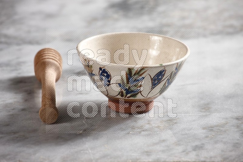 Decorative Pottery bowl with wooden honey handle on the side with grey marble flooring, 15 degree angle