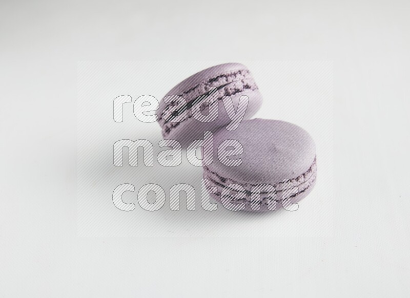 45º Shot of two Purple Blueberry macarons on white background