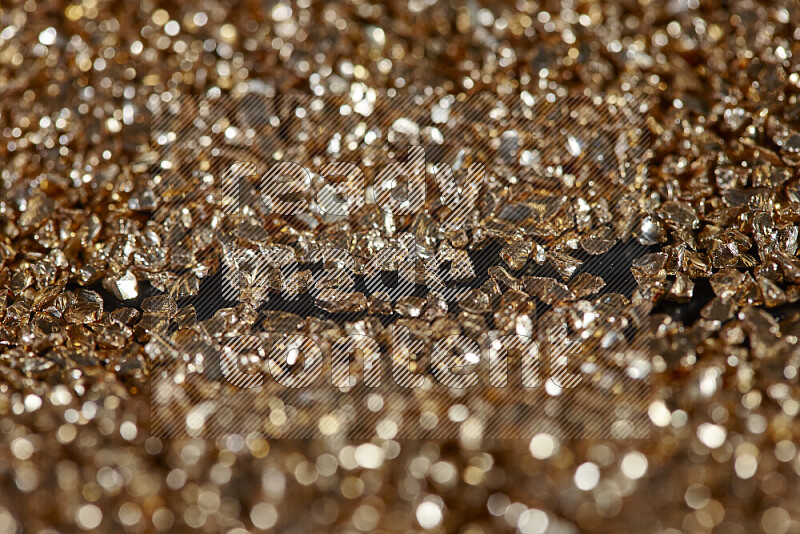 Gold shimmering fragments of glass scattered on a black background