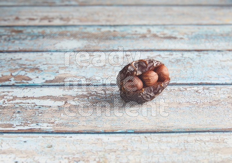 hazelnuts stuffed madjoul date on a light blue wooden background