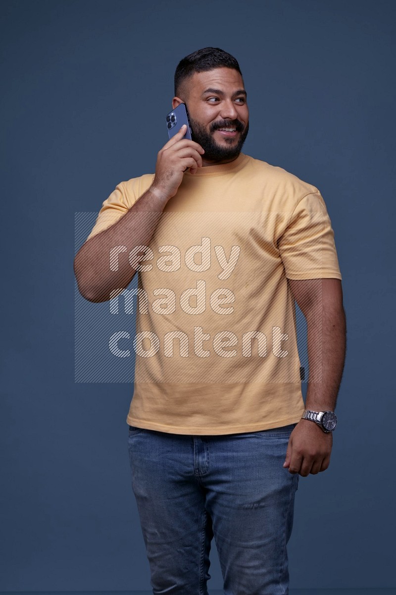 A man Calling on Blue Background wearing Orange T-shirt