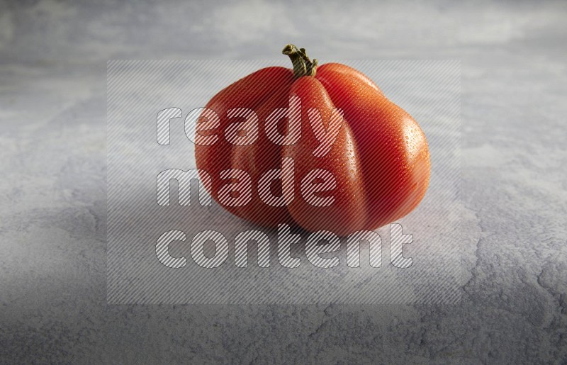 45 degree single heirloom tomato on a light blue textured background