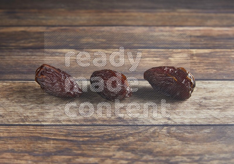 three madjoul dates on a wooden background