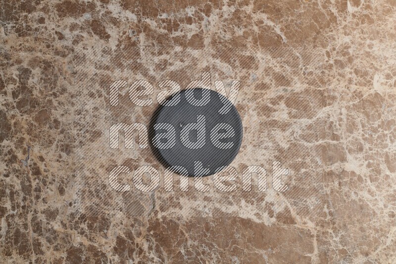 A pottery coaster on beige marble background