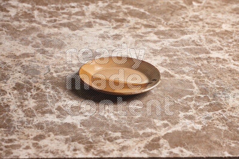A multicolored pottery plate on beige marble background