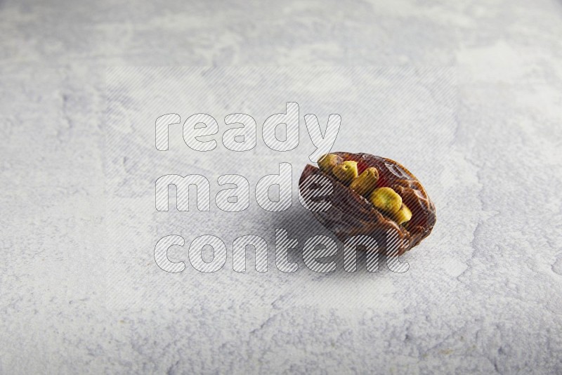pistachio stuffed madjoul date on a light grey background