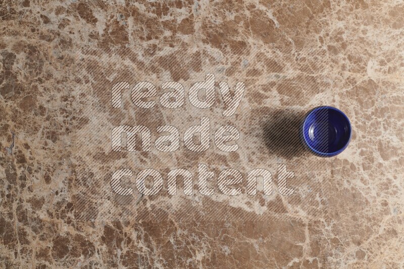 A pottery cup on beige marble background