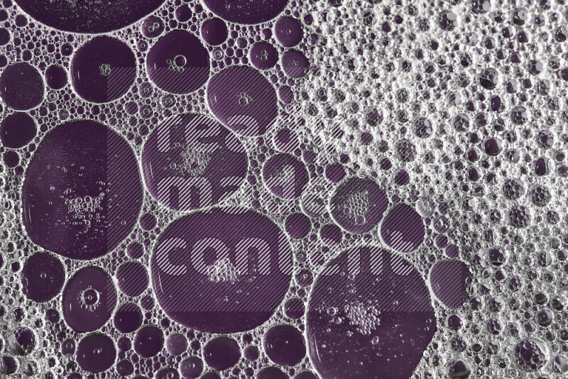 Close-ups of abstract soap bubbles and water droplets on purple background