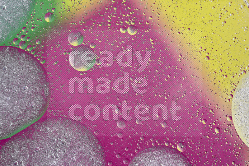 لقطات مقربة لفقاعات من الزيت على سطح الماء باللون الأصفر والأخضر والوردي