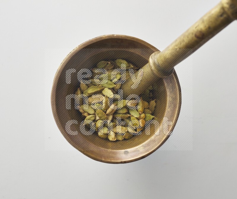 Top-view shot of Cardamon in herbs crusher on white background