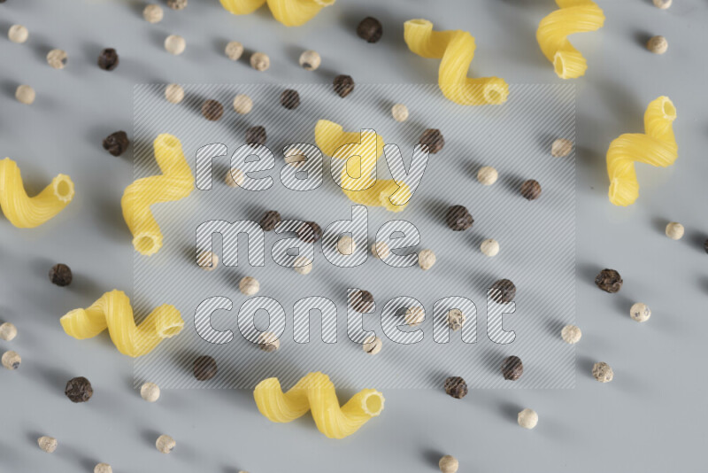 معكرونة مع مكونات متنوعة من الطماطم والثوم والبصل والفلفل الأحمر والفلفل الأسود والفلفل الأبيض وأوراق الغار وإكليل الجبل والهيل و مشروم على خلفية زرقاء فاتحة