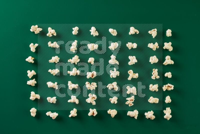 Popcorn flakes on a green background in a top view shot