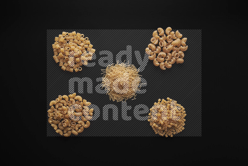 Different pasta types in bunches on black background