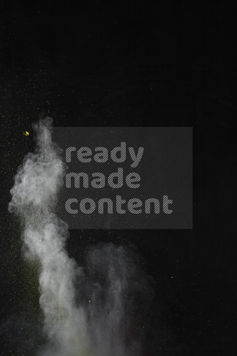 A side view of multicolored powder explosion on black background