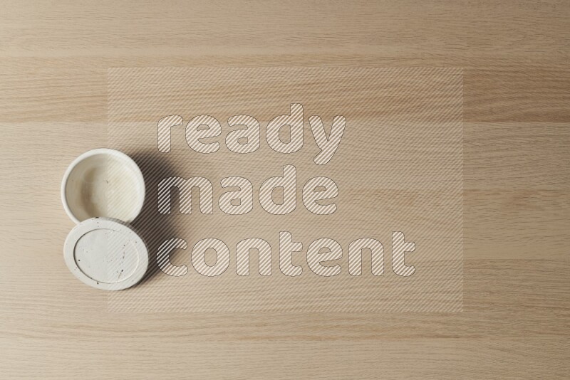 A white pottery bowl on light wooden background