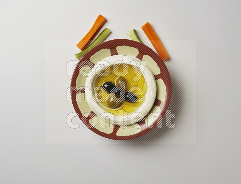 Lebnah garnished with olives in a traditional plate on a white background
