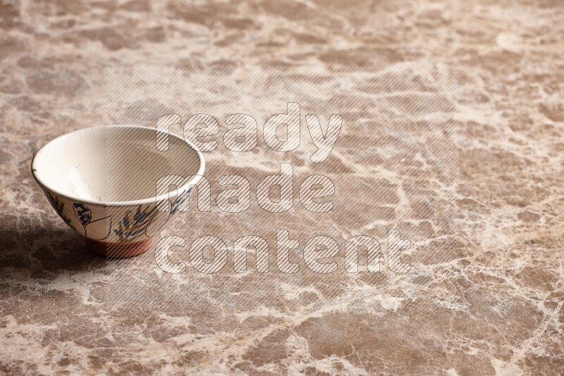 A decorative pottery bowl on beige marble background