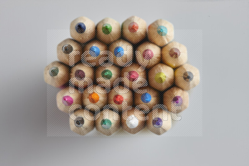 The image captures top view shot of sharpened colored pencils on grey background