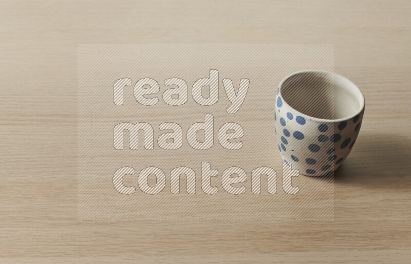 A pottery cup on light wooden background