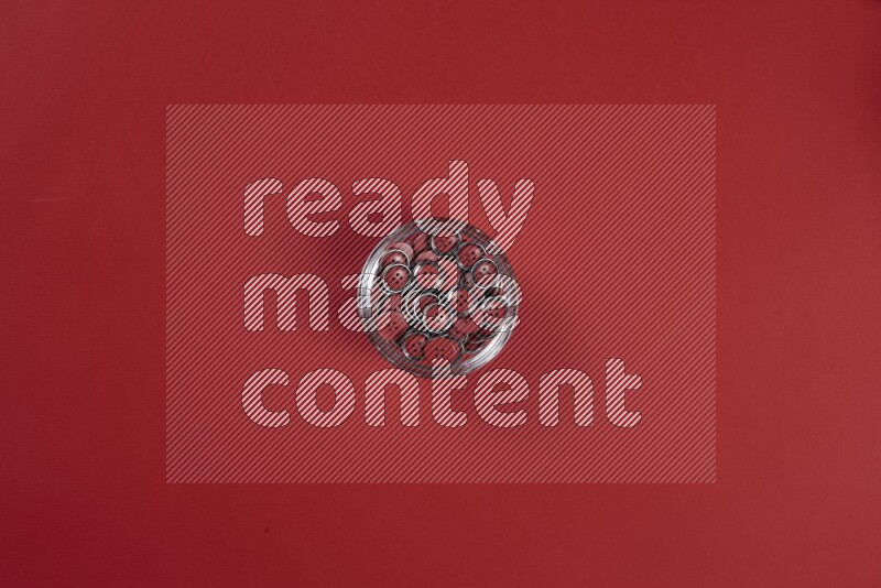 مجموعة من أدوات الخياطة والتفصيل حمراء اللون على خلفية حمراء