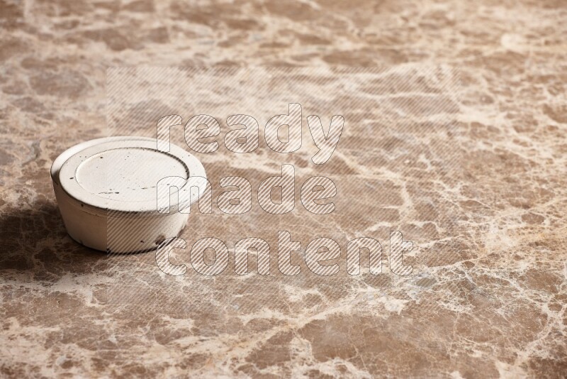 A white pottery bowl on beige marble background