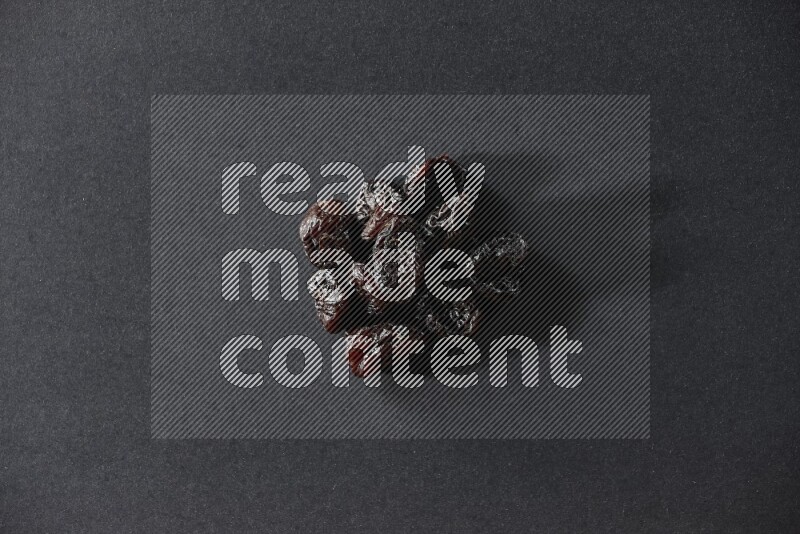 Dried plums on a black background in different angles