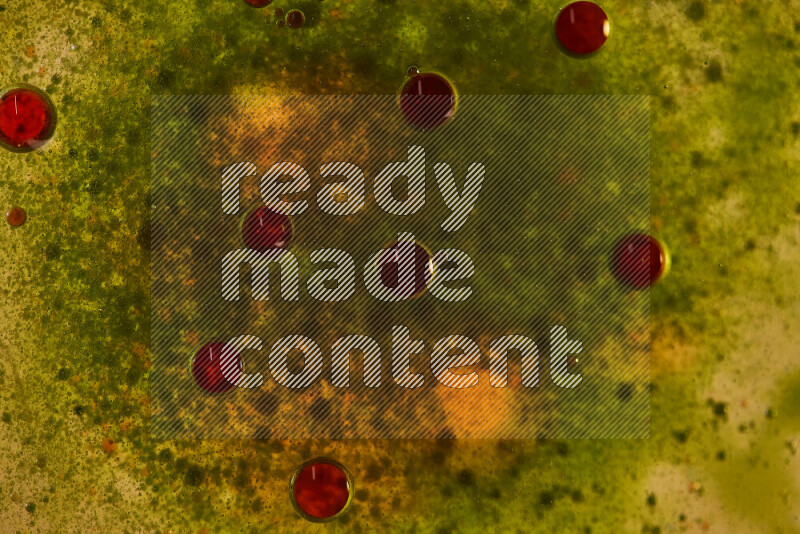 لقطات مقربة لقطرات ألوان مائية حمراء وخضراء على سطح الزيت على خلفية خضراء