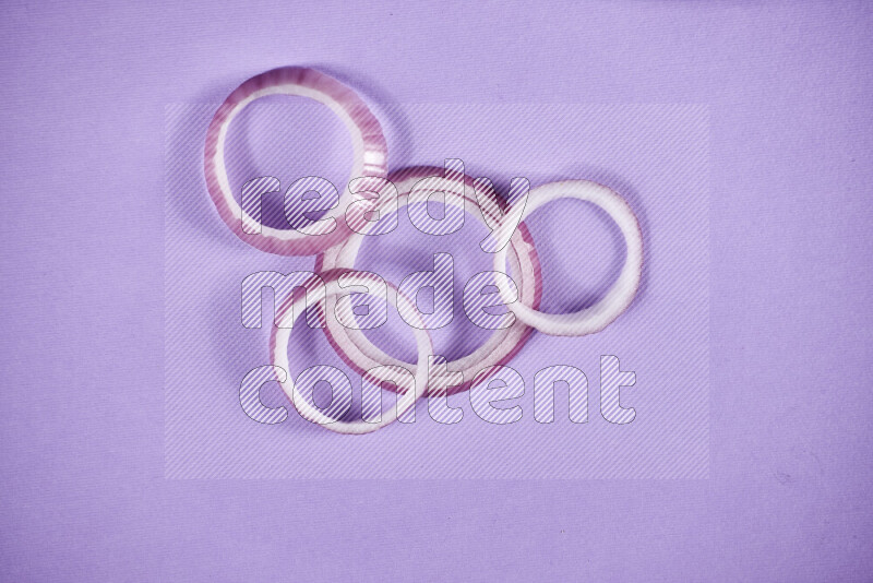 Red onions rings on purple background