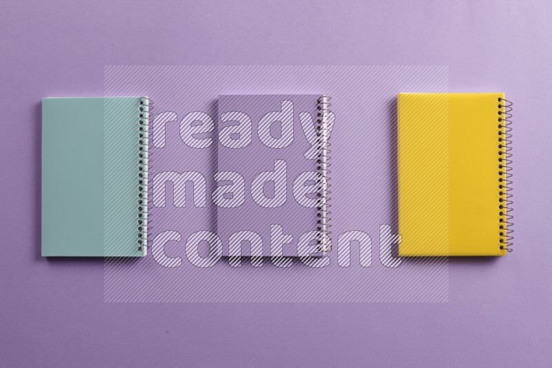 Multicolored notebooks on purple background