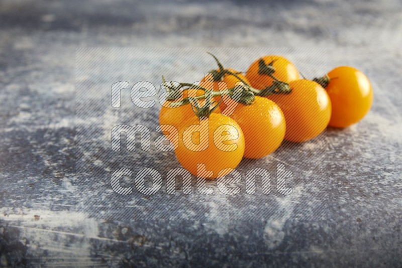 yellow cherry tomato vein on a textured rusty blue background 45 degree