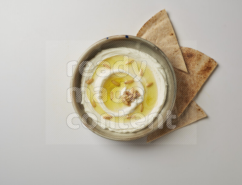 Lebnah garnished with pine nuts in a grey pottery plate on a white background