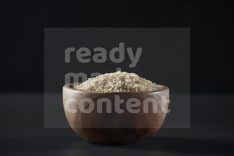 أرز بسمتي في وعاء خشبي على خلفية رمادية