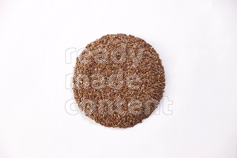 Flax seeds in a circle shape on a white flooring