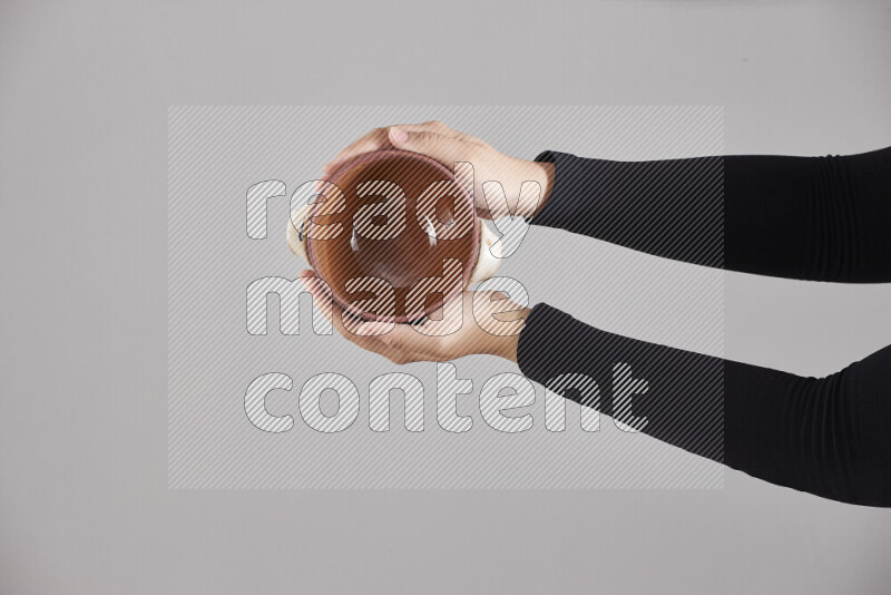A woman in black abaya holding different pottery essentials in different positions