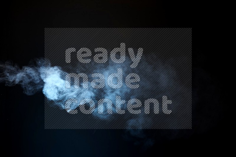 Heavy smoke in blue isolated on black background