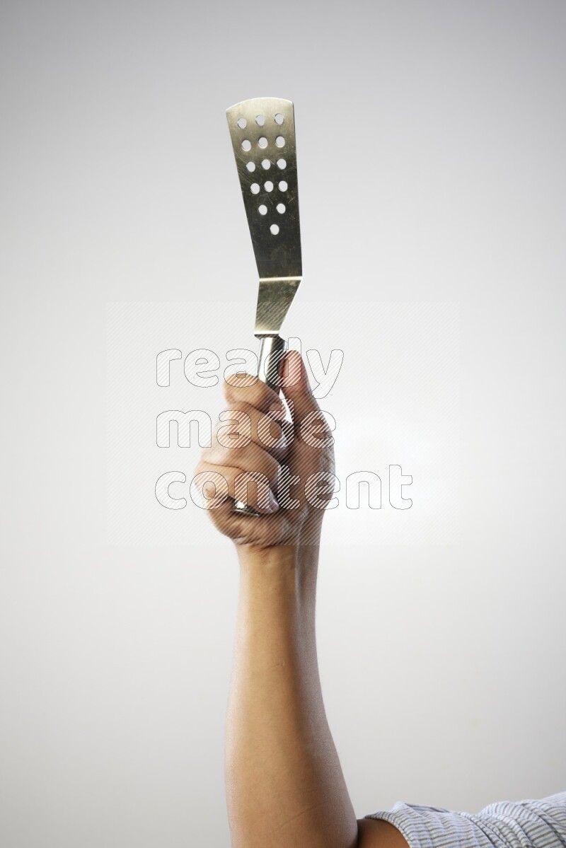 Male Hand Holding Burger Flipper on white background