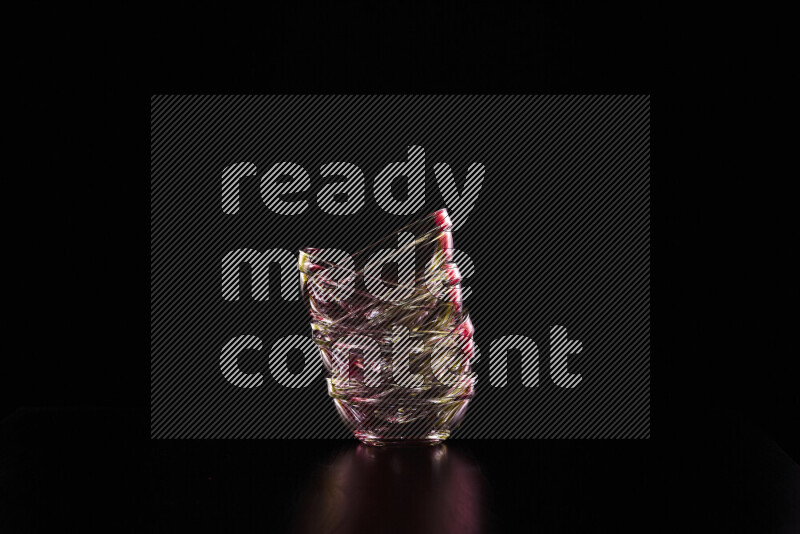 Glassware with rim light in red and yellow against black background