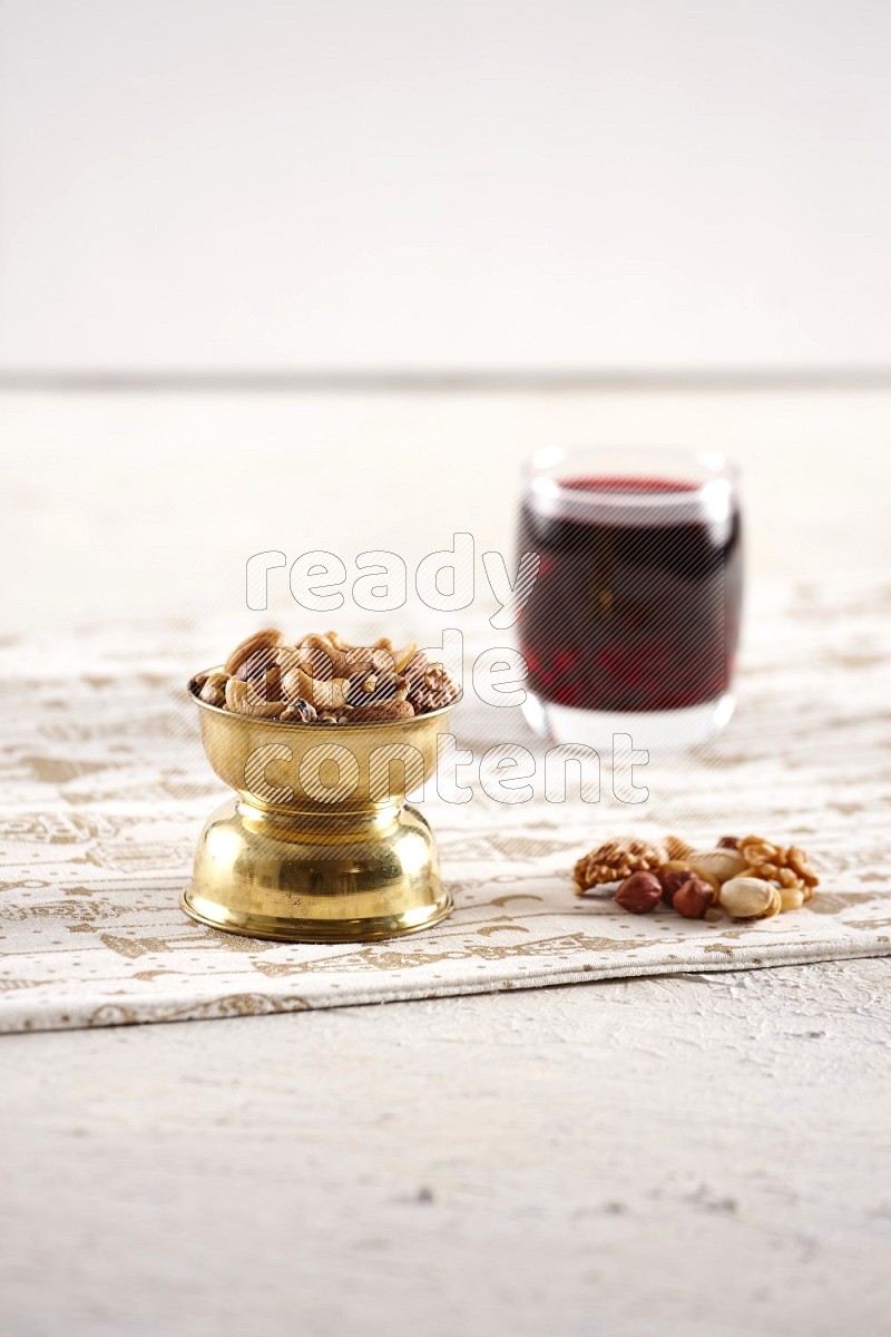 Nuts in a metal bowl with hibiscus in a light setup