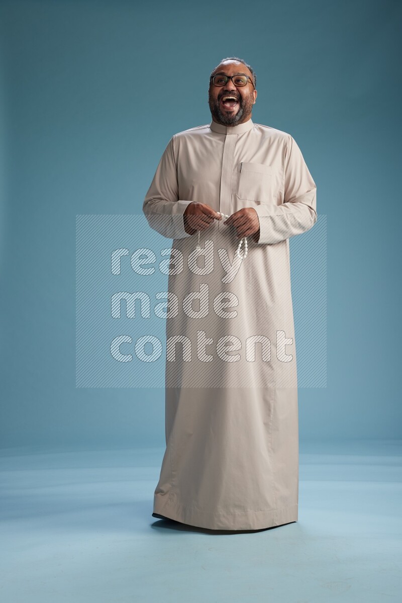 Saudi Man without shimag Standing Interacting with the camera on blue background