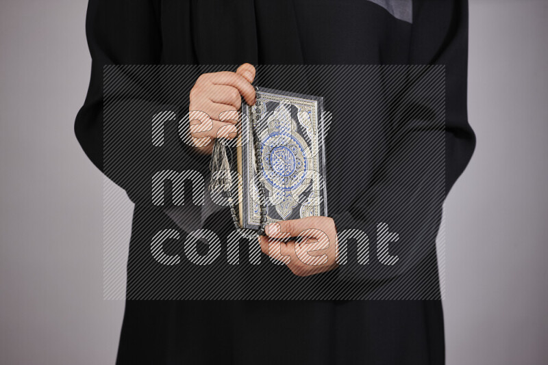 امرأة تحمل بيديها مصحف القرآن في أوضاع متعددة