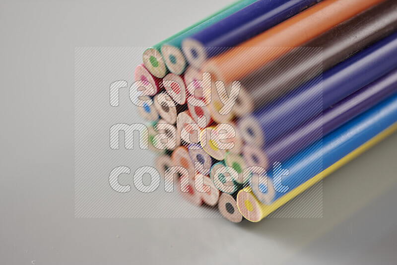 An array of colored pencils on grey background