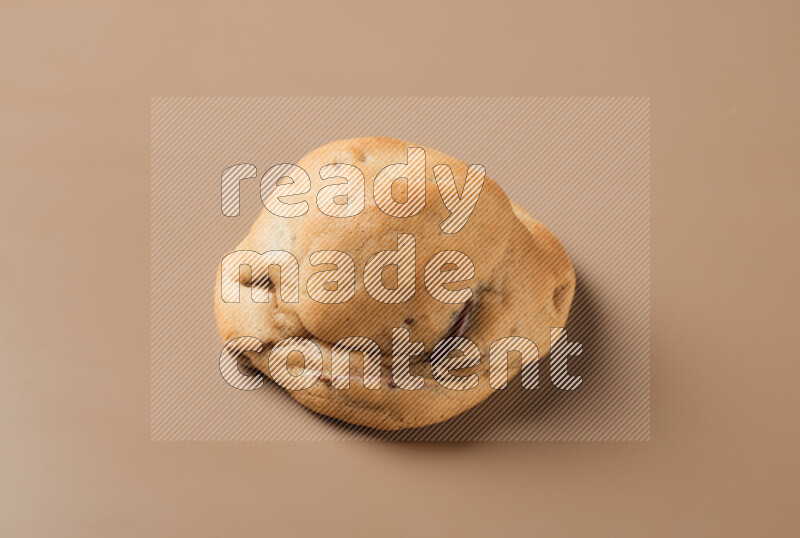 a whole chocolate chip cookie on a brown background
