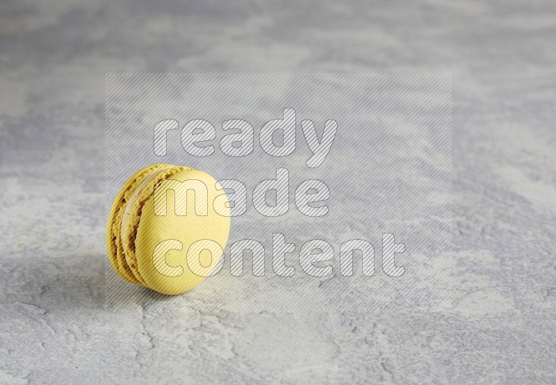 45º Shot of Yellow Lime macaron on white marble