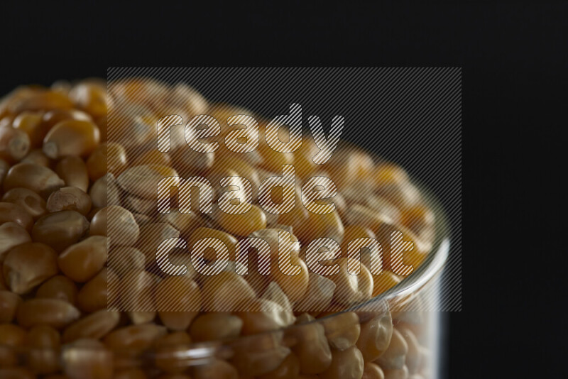 Pop corn in a glass jar on black background