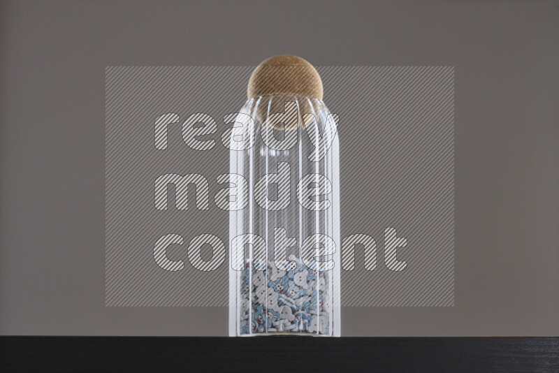 أزرار متنوعة في وعاء زجاجي علي خلفية سوداء