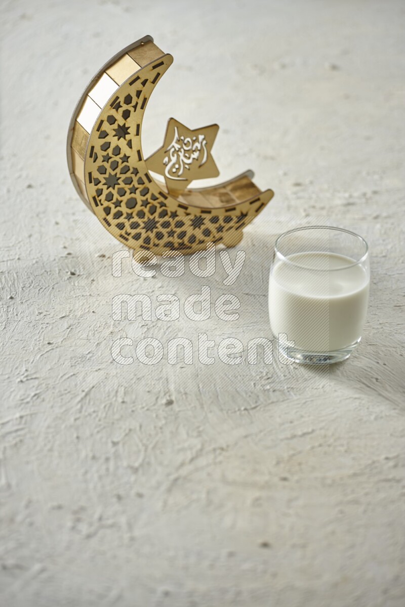 A wooden golden crescent lantern with different drinks, dates, nuts, prayer beads and quran on white background