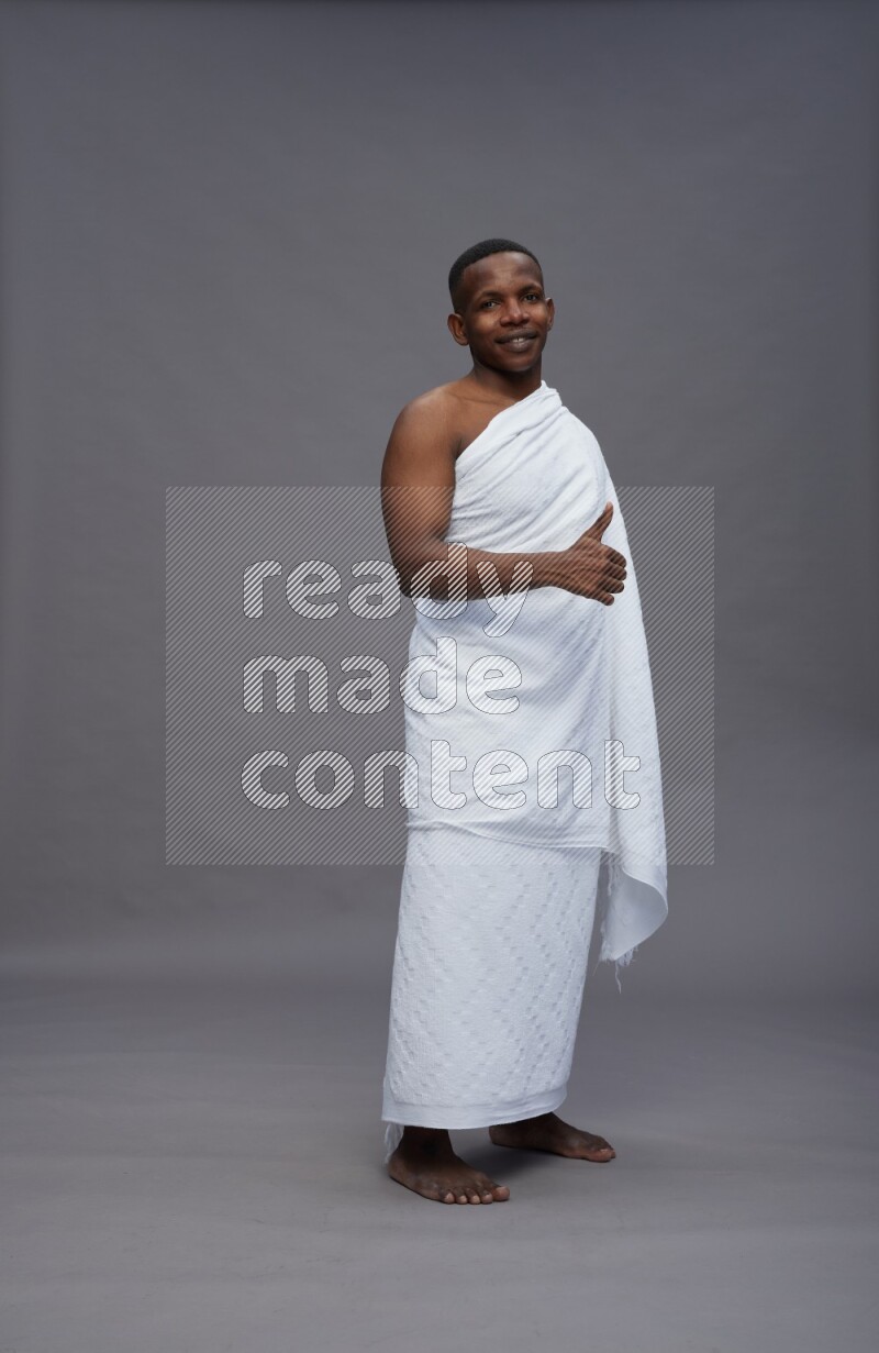 A man wearing Ehram Standing Interacting with the camera on gray background